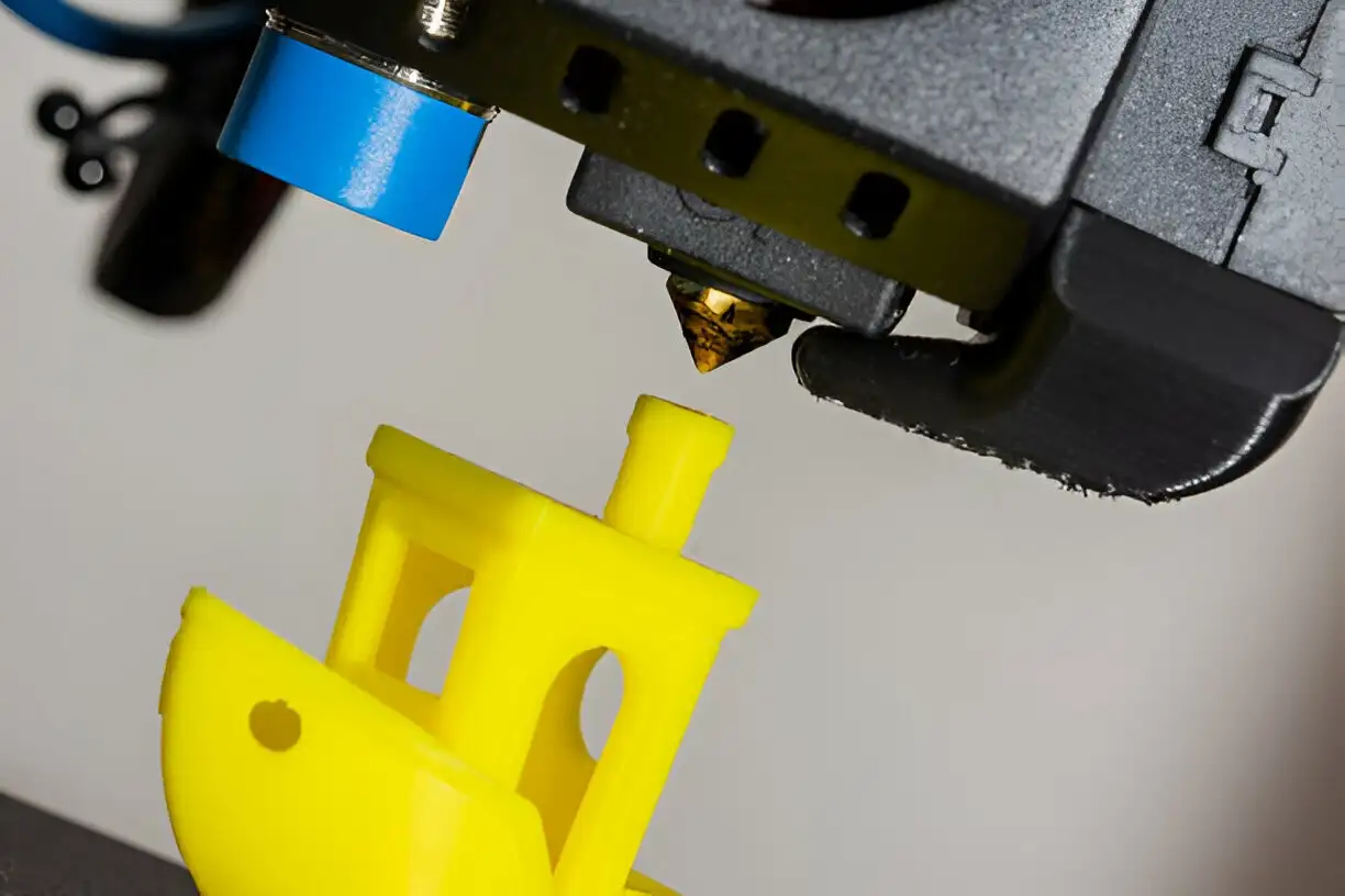 3d printing-plastic ABS ship model. Yellow filament. Modern 3D printer printerhead